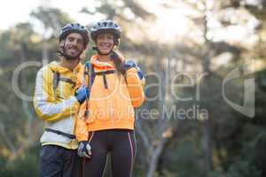 Biker couple standing in countryside forest