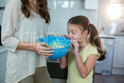 Mother and daughter with bowl of breakfast