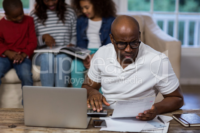 Man using calculator to check the bills