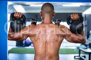 Man exercising with kettlebells in gym