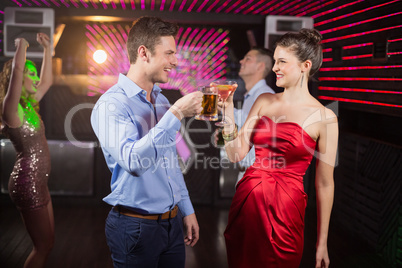 Smiling couple toasting glass of beer and cocktail