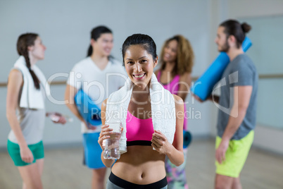 Portrait of woman holding water bottle and towel