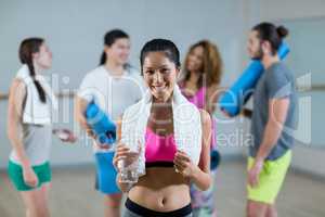 Portrait of woman holding water bottle and towel