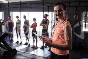 Happy female fitness instructor holding clipboard