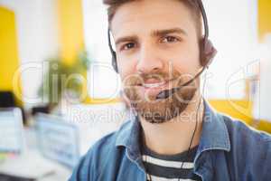 Portrait of confident executive wearing headphones at creative office