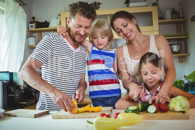 Family chopping vegetables in the kitchen