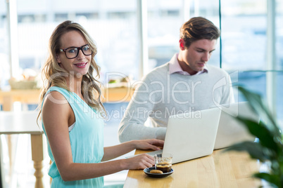 Man and woman using laptop during meeting