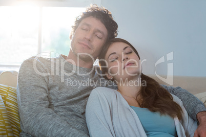 Couple sleeping together on sofa