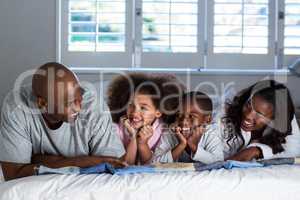 Happy family lying on bed