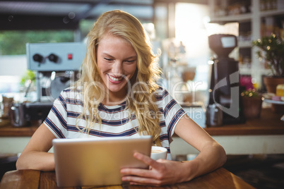 Woman sitting in a cafe using digital tablet