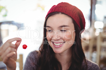 Smiling woman holding cherry