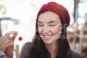 Smiling woman holding cherry