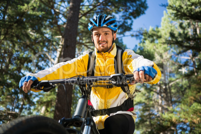 Male mountain biker riding bicycle in the forest