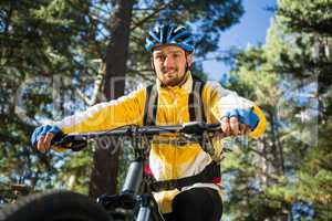 Male mountain biker riding bicycle in the forest