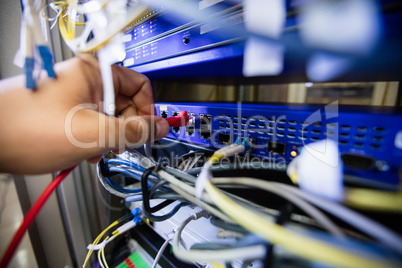 Technician fixing patch cable in a rack mounted server