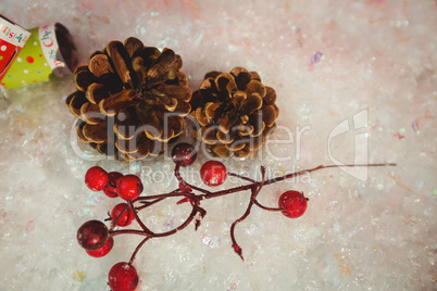 Pine cone, cherry and christmas crackers on snow