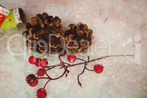 Pine cone, cherry and christmas crackers on snow