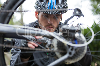 Male cyclist repairing his mountain bike