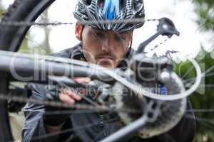 Male cyclist repairing his mountain bike