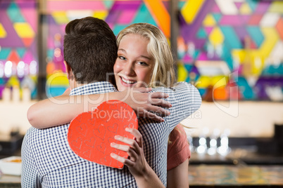 Couple embracing each other while holding gift