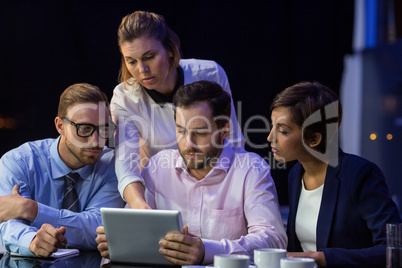 Businesswoman discussing on digital tablet with her colleagues