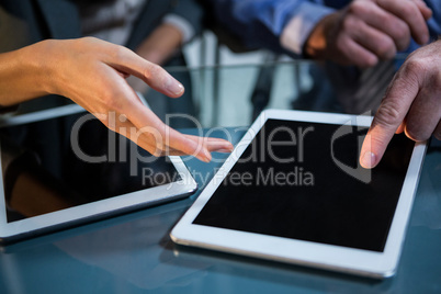 Businessman discussing with colleague over digital tablet