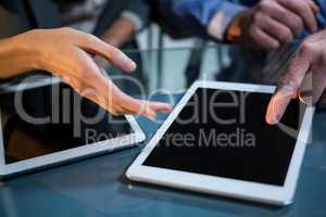 Businessman discussing with colleague over digital tablet