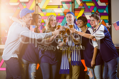 Group of friends toasting glass of beer in party