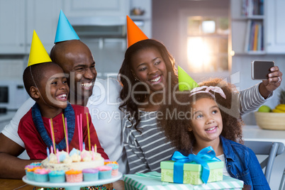 Family taking selfie with birthday cake