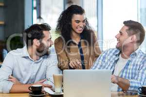 Friends using laptop in cafÃ?Â©