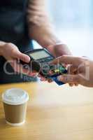 Man paying bill through payment terminal