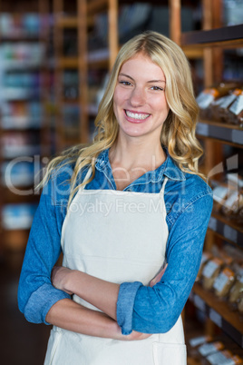 Portrait of smiling female staff standing with hands crossed