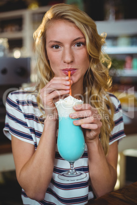 Portrait of woman drinking milkshake with a straw