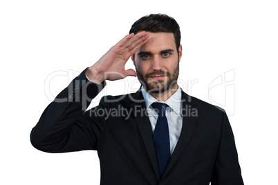Businessman saluting against white background