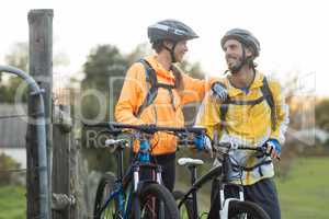Biker couple interacting while standing with mountain bike