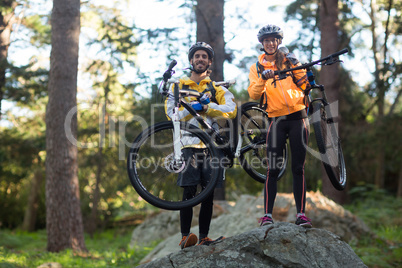 Portrait of biker couple carrying mountain bike