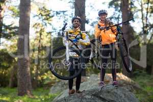 Portrait of biker couple carrying mountain bike