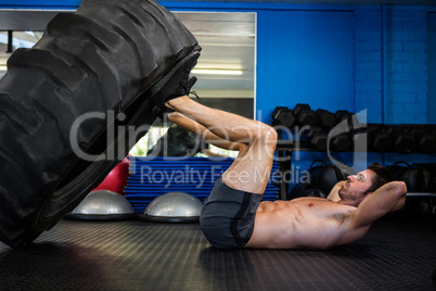 Man exercising with tire in gym