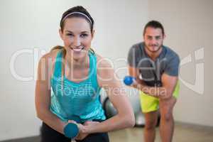 Portrait of man and woman doing aerobic exercise with dumbbell