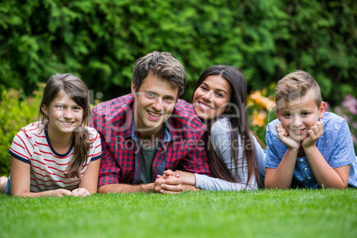 Portrait of happy family lying in park