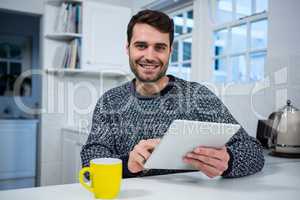 Man using digital tablet in the kitchen