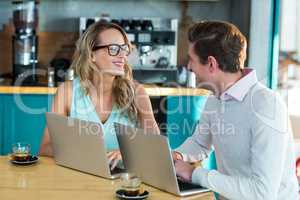 Man and woman using laptop during meeting