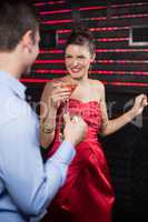 Smiling couple holding glass of beer and cocktail while dancing