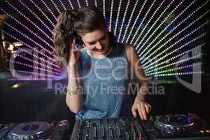 Pretty female DJ playing music