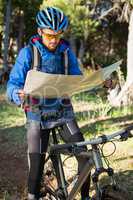 Male mountain biker looking at map