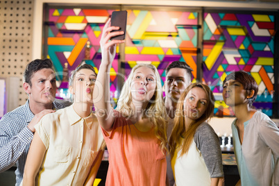 Group of smiling friends taking a selfie from mobile phone