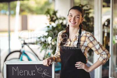 Waitress standing with menu board outside the cafe