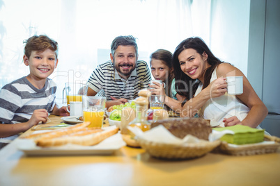 Portrait of happy family having breakfast together