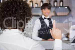 Man ordering a drink at bar counter