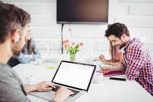 Executive using laptop in meeting at creative office